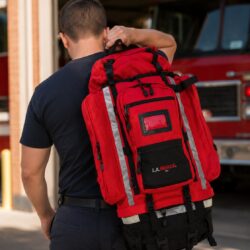 L.A. Rescue Ultimate 72 Hour Deployment Pack in use - firefighter shouldering the pack at the apparatus bay