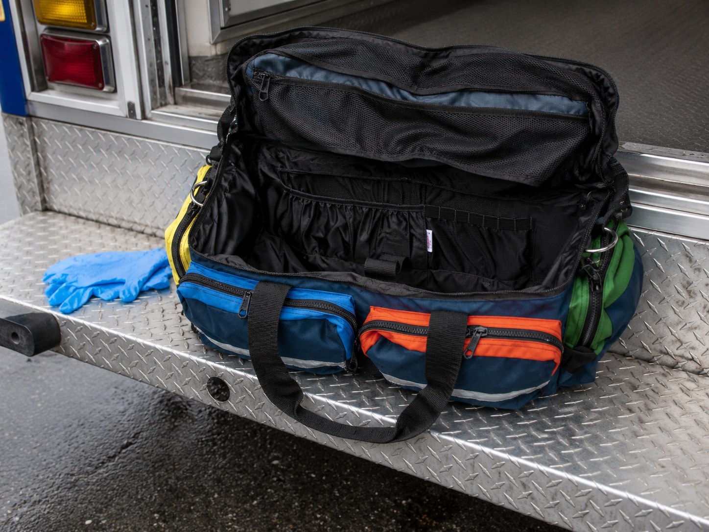 O2 To Go Pro Plus open on the ambulance step - color-coded pouches and mesh lid storage