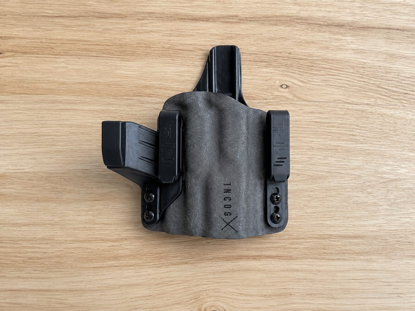 Flat-lay of the IncogX IWB holster showing its slim profile, clips, and weapon-light channel